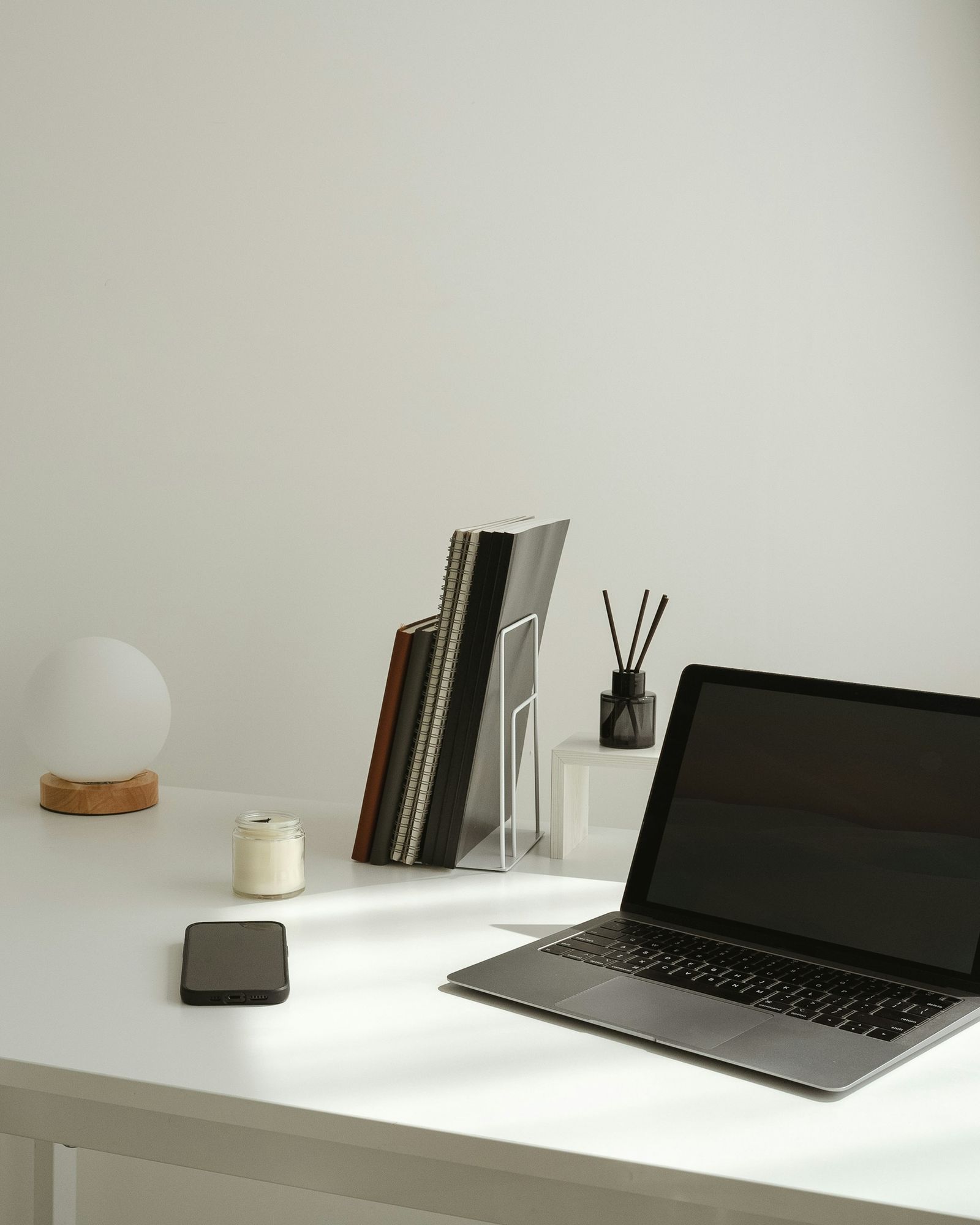 A laptop and books on a white desk